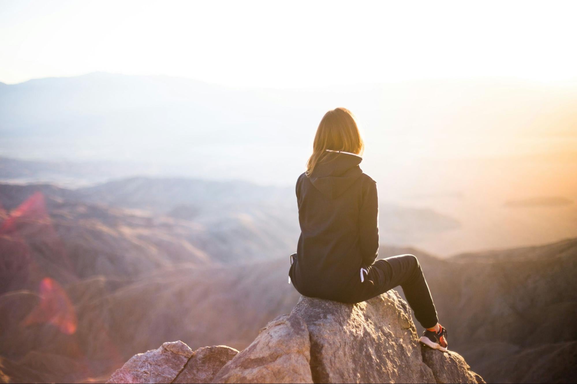 Woman viewing sunset from mountaintop
