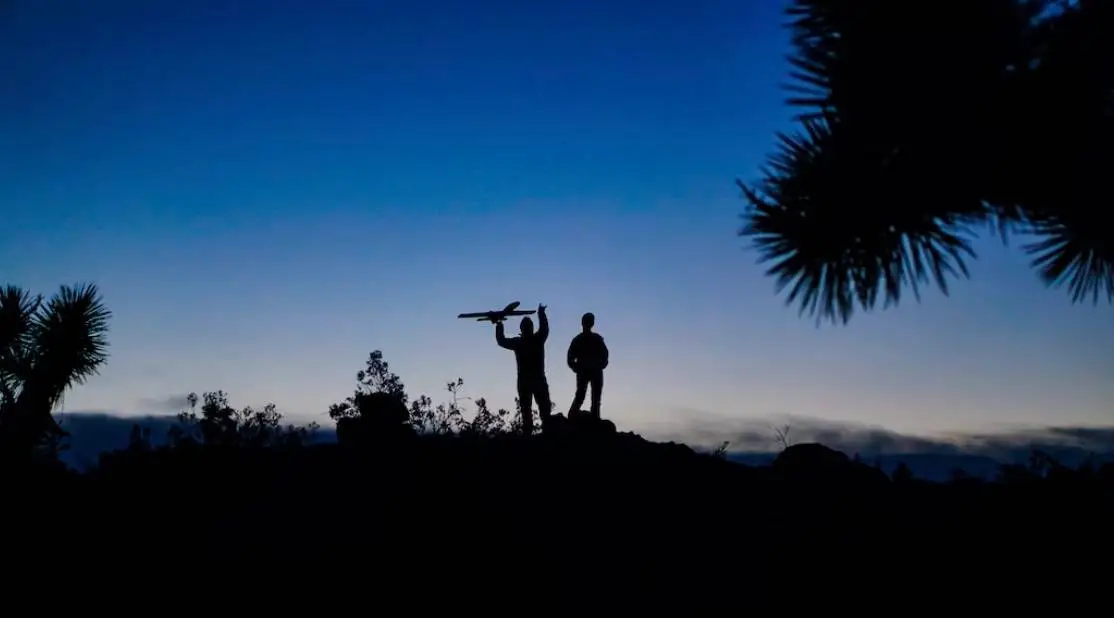 Father and son on horizon playing with drone