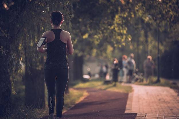 Woman running on a paved path, demonstrating pain-free exercise